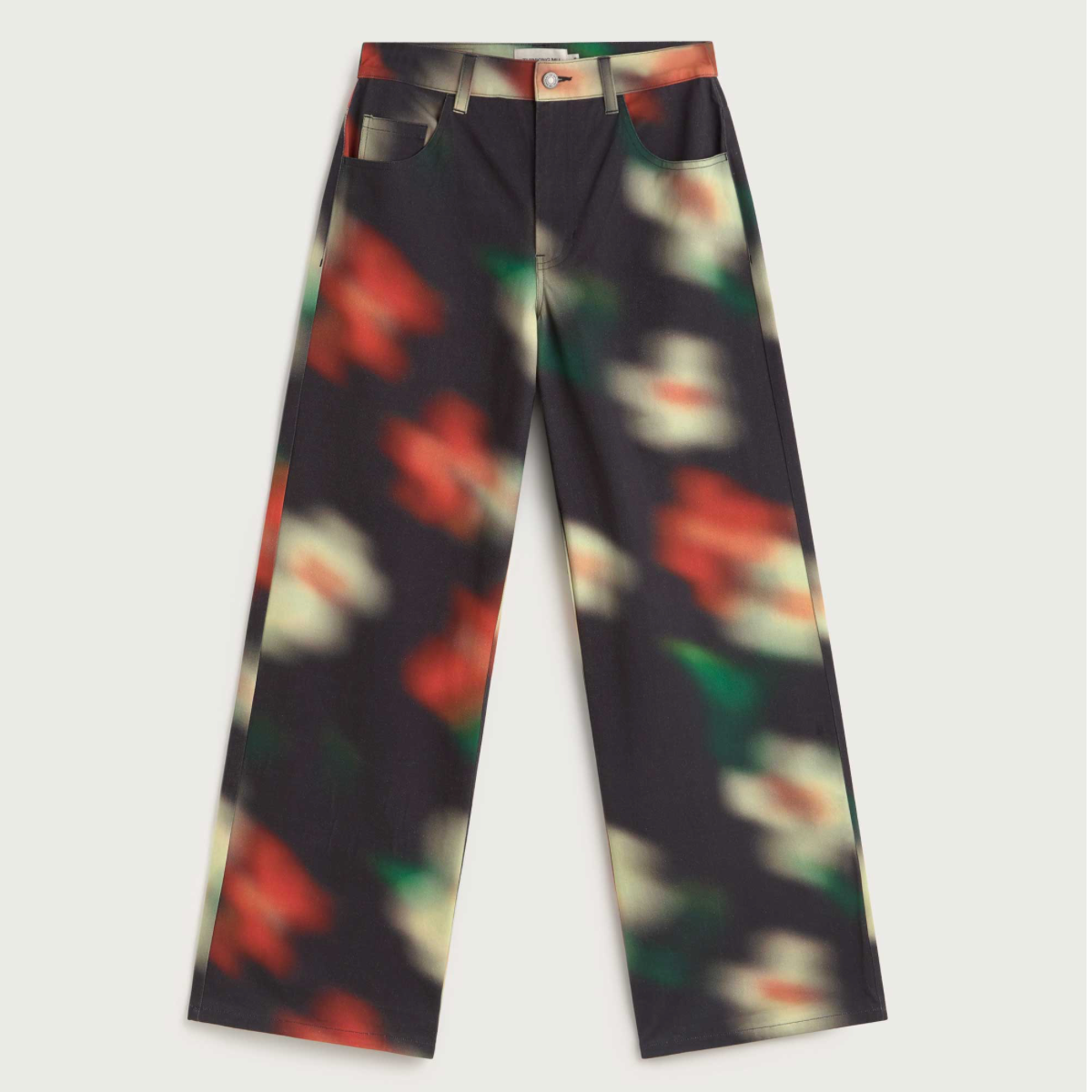 A pair of wide-leg trousers featuring a dark charcoal base with a colorful, blurred abstract floral pattern in red, green, and cream.