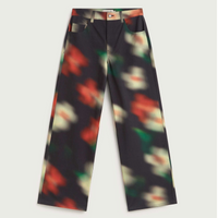 A pair of wide-leg trousers featuring a dark charcoal base with a colorful, blurred abstract floral pattern in red, green, and cream.